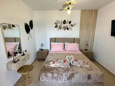 a bedroom with a bed with pink and white towels on it at Anemos Villa Stegna in Archangelos