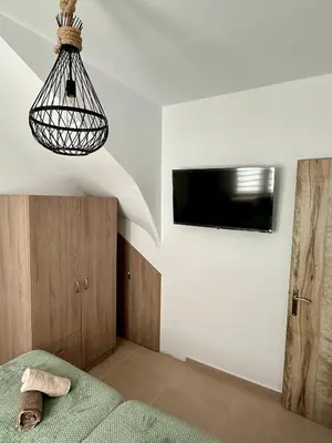 a bedroom with a bed and a tv on the wall at Anemos Villa Stegna in Archangelos