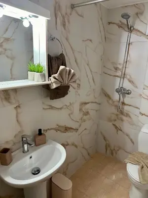 a white bathroom with a sink and a toilet at Anemos Villa Stegna in Archangelos