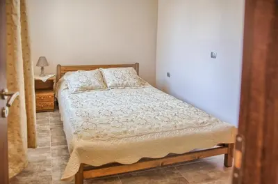 a small bedroom with a bed and a desk at Despinas Seafront Apartments,Haraki in Haraki