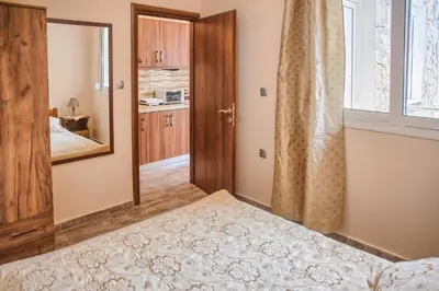 a bedroom with a bed and a mirror and a window at Despinas Seafront Apartments,Haraki in Haraki