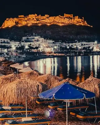 a group of boats sitting on the water at night at Despinas Seafront Apartments,Haraki in Haraki