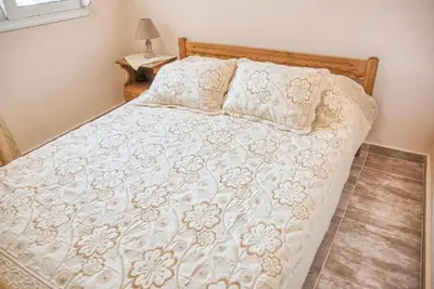 a bedroom with a bed with a white comforter and pillows at Despinas Seafront Apartments,Haraki in Haraki