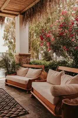 two beds on a patio with flowers and plants at Maya pool & mountain view villa in Koskinou