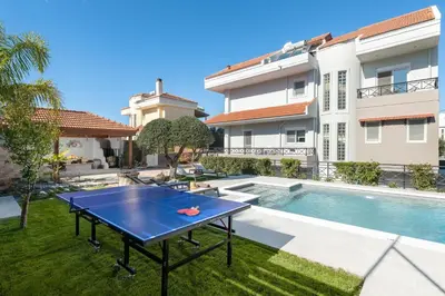 a ping pong table in the backyard of a house at Emmelia Villa in Ialyssos