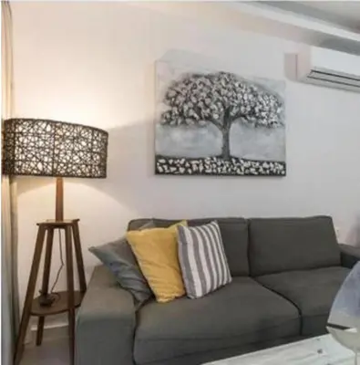a living room with a couch and a tree on the wall at Rhodes Center Luxurious Penthouse in Rhodes Town