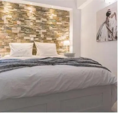 a bedroom with a bed with a brick wall at Rhodes Center Luxurious Penthouse in Rhodes Town