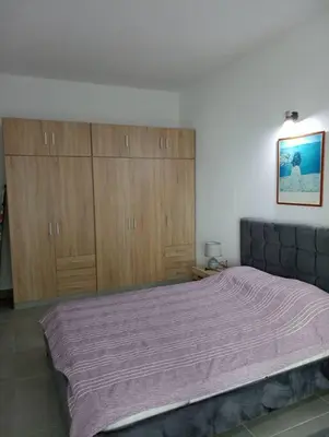 a bedroom with a large bed and wooden cabinets at Katias downtown apartment in Rhodes Town