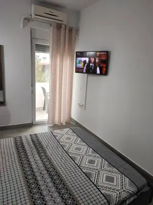 a bedroom with a bed with a tv on the wall at Katias downtown apartment in Rhodes Town