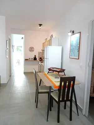 a kitchen with a table and chairs and a refrigerator at Katias downtown apartment in Rhodes Town