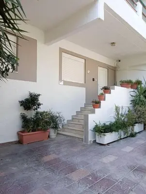a white house with potted plants on the stairs at Katias downtown apartment in Rhodes Town