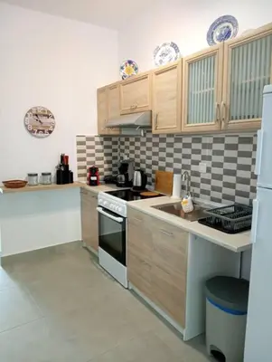 a kitchen with wooden cabinets and a stove top oven at Katias downtown apartment in Rhodes Town