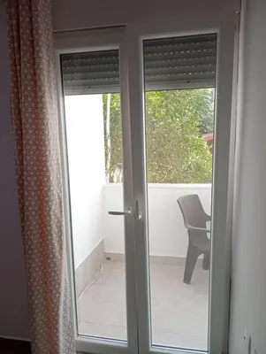 a sliding glass door with a chair on a balcony at Katias downtown apartment in Rhodes Town