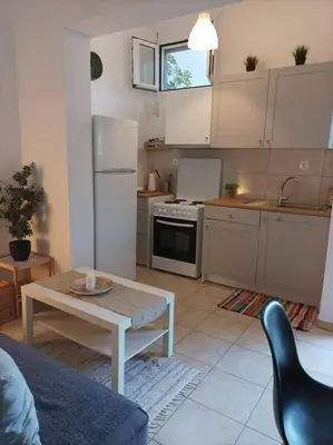 a kitchen with a table and a refrigerator and a table at Comfy Cozy Iksia in Ixia