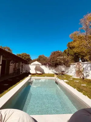 a swimming pool in a yard next to a house at Naya pool & garden view bungalow in Koskinou