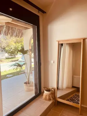 a room with a glass door with a potted plant at Naya pool & garden view bungalow in Koskinou