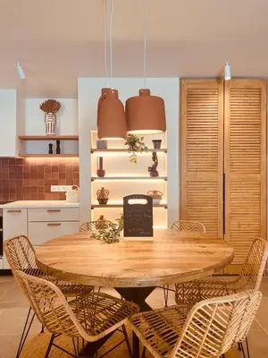 a kitchen with a wooden table and chairs at Naya pool & garden view bungalow in Koskinou