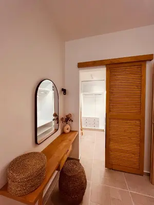 a room with a mirror and a bench and a door at Naya pool & garden view bungalow in Koskinou
