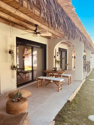 a patio with a table and a ceiling fan at Naya pool & garden view bungalow in Koskinou