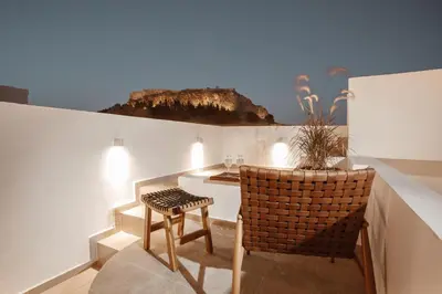 a dining room with a table and a chair at Noema Lindos - Angeliki Suite in Líndos
