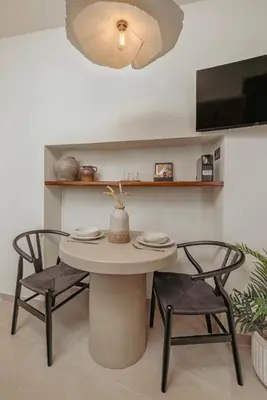 a table and chairs in a room with a tv at Noema Lindos - Angeliki Suite in Líndos