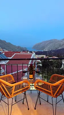a table and chairs on a balcony with a view at Casa Chara 2 in Symi
