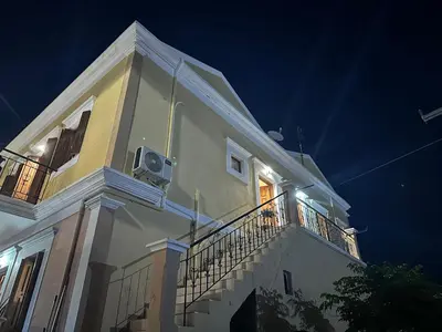 a white building with a balcony at night at Casa Chara 2 in Symi