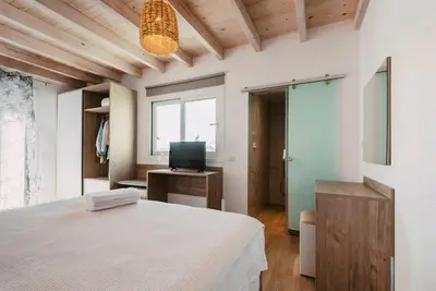 a bedroom with a large bed and a television at Myrovolos luxury Eneida's house in Ialyssos