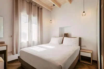 a bedroom with a large white bed and a window at Myrovolos luxury Eneida's house in Ialyssos