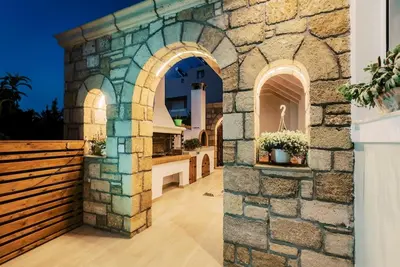 a stone wall with an archway in a house at Myrovolos luxury Eneida's house in Ialyssos