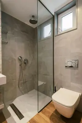 a bathroom with a toilet and a glass shower at Myrovolos luxury Angie's house in Ialyssos