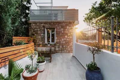 a patio with potted plants and a building at Myrovolos luxury Angie's house in Ialyssos