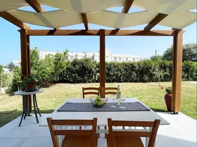 a table and chairs under a wooden pergola at Gennadi Big House in Gennadi