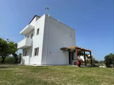 a white building with a fire hydrant in front of it at Gennadi Big House in Gennadi