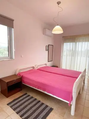 a large pink bed in a white room with a window at Gennadi Big House in Gennadi