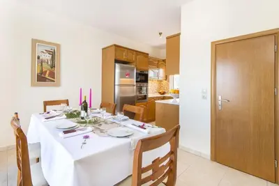 a dining room with a table and a kitchen at Pearl Villas Gennadi in Gennadi