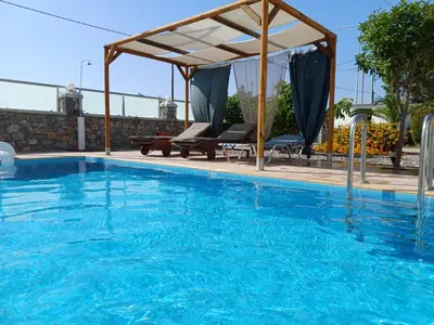 a swimming pool with a gazebo and a swimming pool at Pearl Villas Gennadi in Gennadi