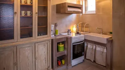 a small kitchen with a sink and a stove at Chic & Modern Apartments with swim access in Halki