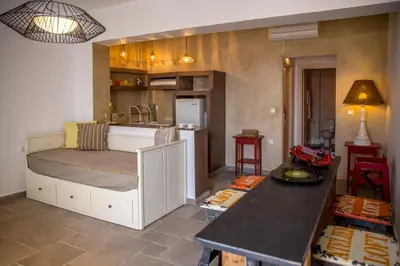 a bedroom with a bed and a kitchen with a counter at Chic & Modern Apartments with swim access in Halki