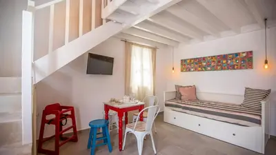 a bedroom with a bed and a table and chairs at Chic & Modern Apartments with swim access in Halki