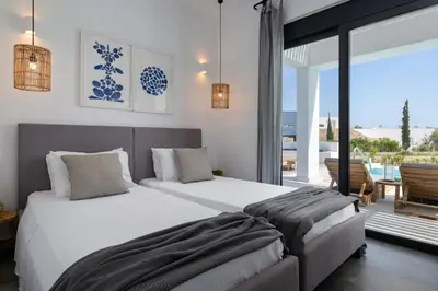 a bedroom with two beds and a balcony at Seastar Villa Large Pool & Jacuzzi Retreat in Lachania