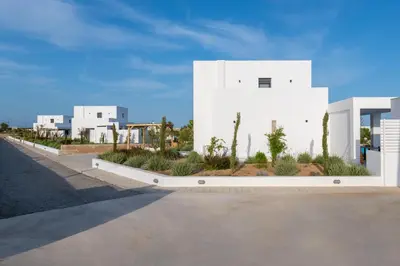 a white building with trees and plants on a street at Seastar Villa Large Pool & Jacuzzi Retreat in Lachania