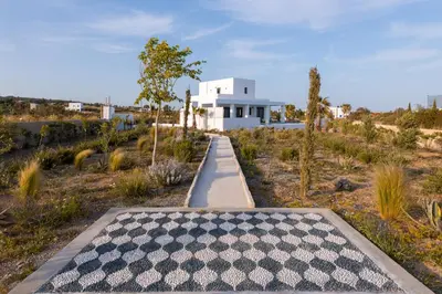 a walkway leading to a white house in a desert at Seastar Villa Large Pool & Jacuzzi Retreat in Lachania