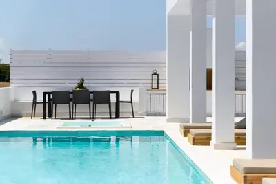 a patio with a table and chairs next to a swimming pool at Seastar Villa Large Pool & Jacuzzi Retreat in Lachania
