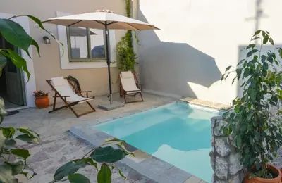a small pool with two chairs and an umbrella at Anassa Mountain House in Émbonas