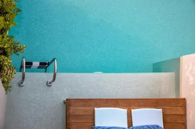 a bathroom with two white chairs and a mirror at Lindos Mare, Seaside Hotel in Líndos