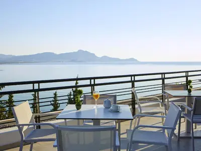 a table and chairs on a balcony with a view of the water at Lindos Mare, Seaside Hotel in Líndos