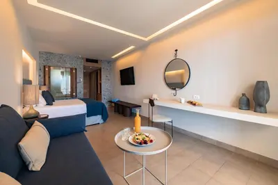 a hotel room with a bed and a living room at Lindos Mare, Seaside Hotel in Líndos