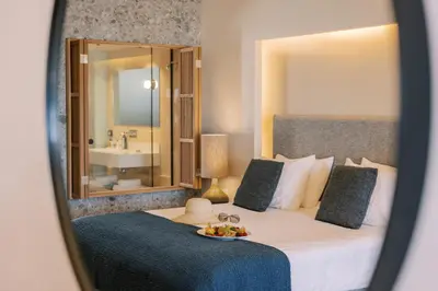 a bedroom with a bed with a bowl of fruit on it at Lindos Mare, Seaside Hotel in Líndos