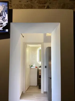 a hallway leading to a kitchen with a refrigerator at Casa Charma in Émbonas